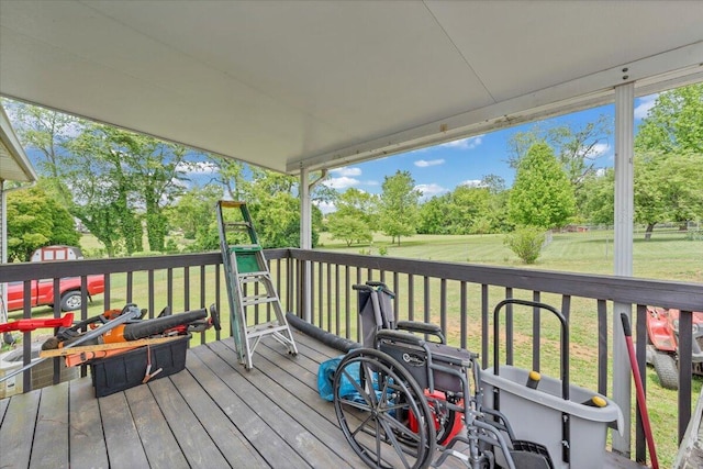 wooden deck with a lawn and view of wooded area