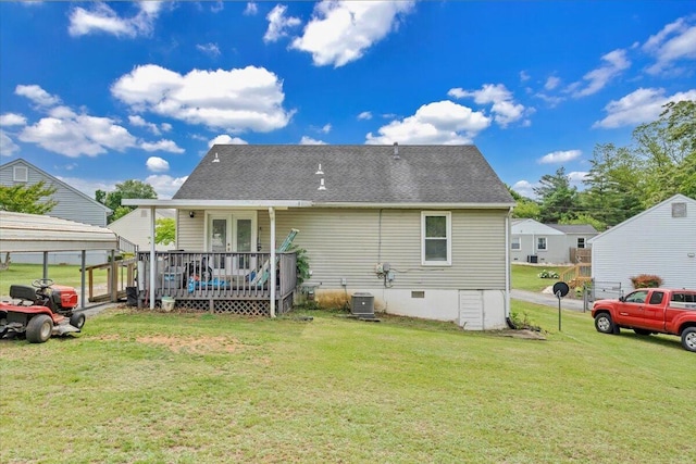 rear view of house with a wooden deck, a lawn, central AC, and a shingled roof