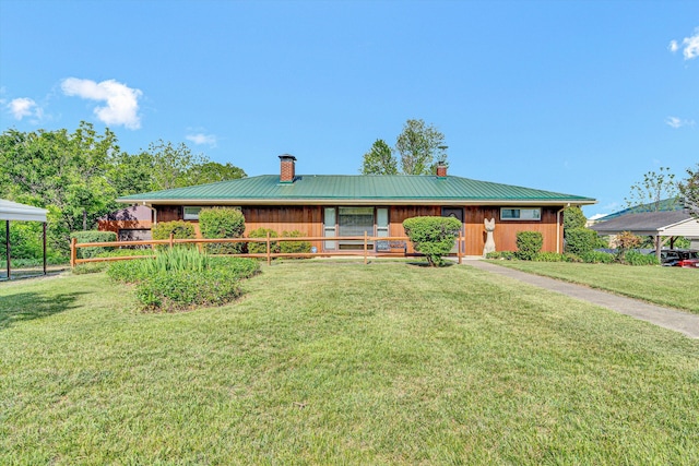 single story home featuring a chimney, metal roof, a front yard, and a porch