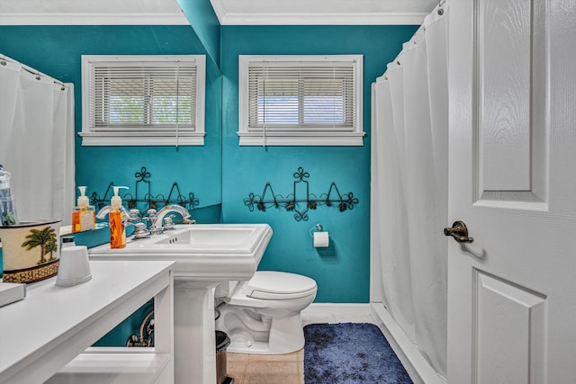 bathroom featuring ornamental molding, toilet, tile patterned flooring, and baseboards
