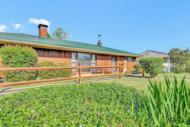 view of front of property featuring a chimney and metal roof