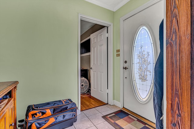 entrance foyer with light tile patterned flooring, ornamental molding, and baseboards