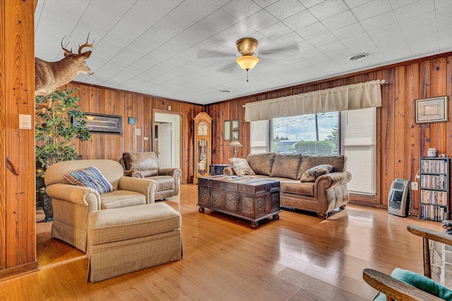 living area with wood walls, heating unit, and wood finished floors