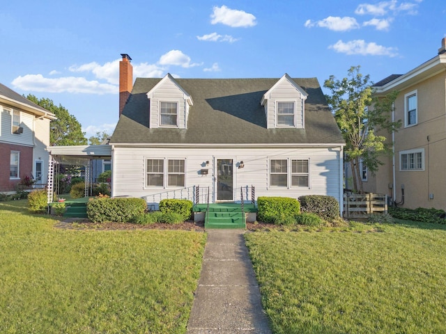 new england style home featuring a front yard, a chimney, and roof with shingles