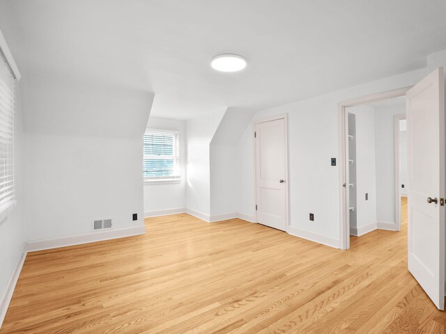 bonus room with light wood-style flooring and baseboards