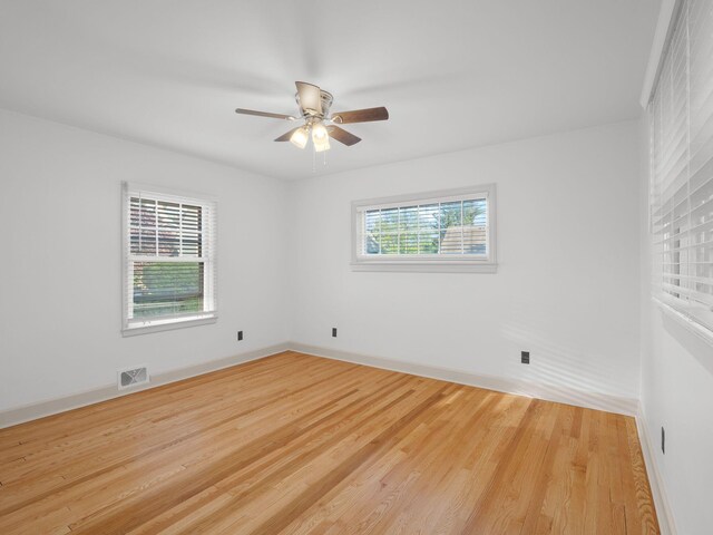 empty room featuring ceiling fan, wood finished floors, and baseboards