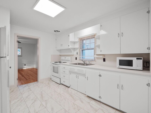 kitchen featuring white appliances, a sink, open shelves, light countertops, and white cabinetry