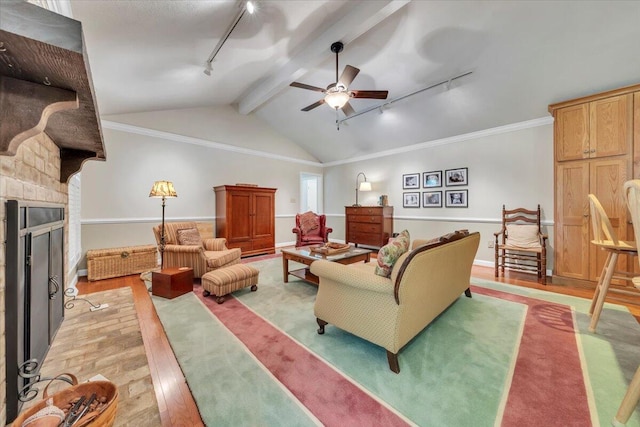 living area with rail lighting, light wood-type flooring, ceiling fan, and a fireplace