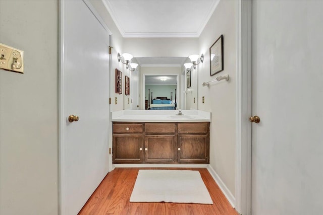 bathroom with wood finished floors, vanity, ensuite bathroom, and crown molding