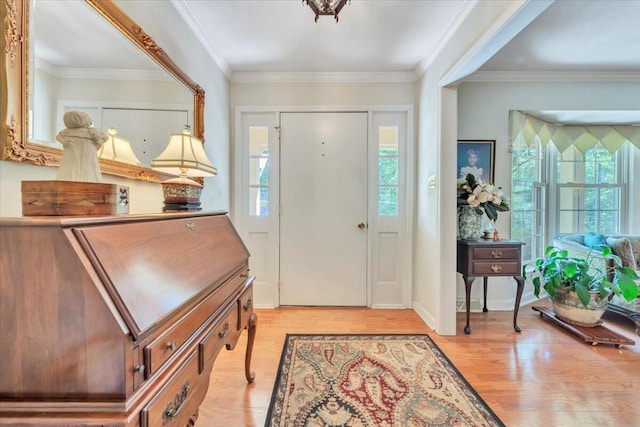 foyer with healthy amount of natural light, light wood-type flooring, and crown molding