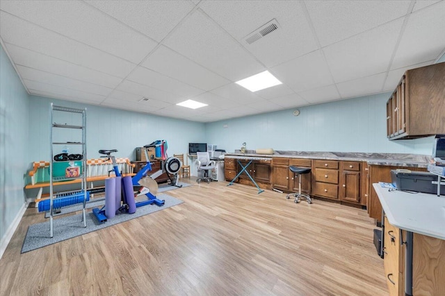 office area featuring light wood-type flooring and a drop ceiling