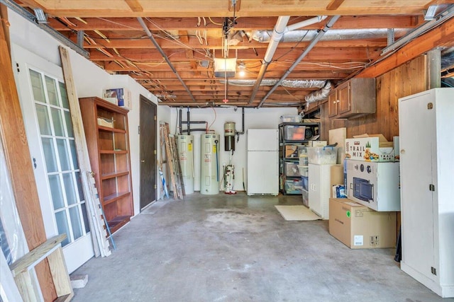 below grade area featuring freestanding refrigerator, electric water heater, water heater, and a central vacuum unit