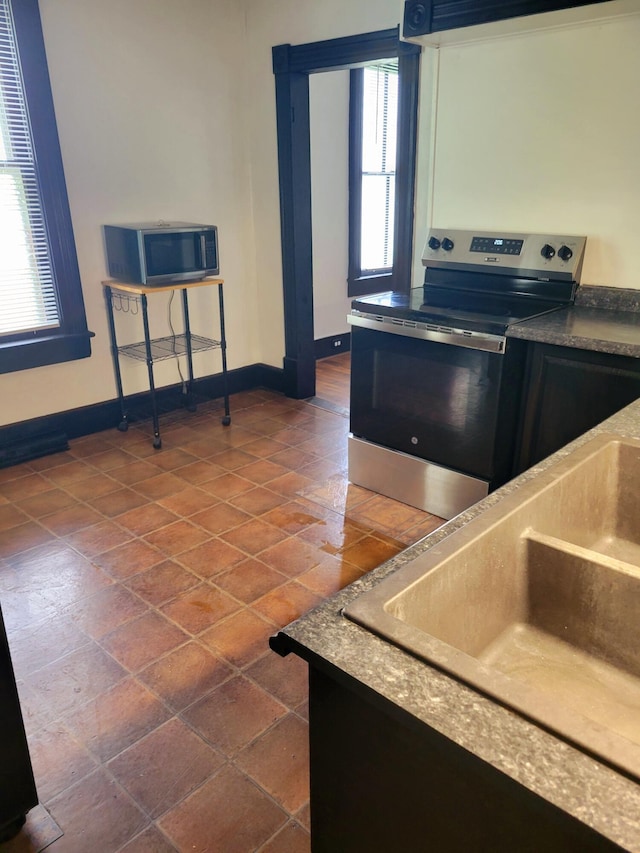 5159 Lee Hwy, Troutville, VA 24175 - kitchen with appliances with stainless steel finishes, a sink, baseboards, ventilation hood, and dark countertops