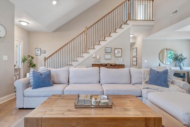 living room featuring wood finished floors, stairway, and baseboards