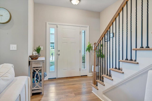 foyer entrance with light wood-style floors and stairs