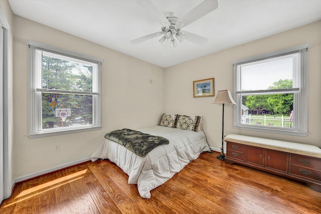 bedroom with baseboards, wood finished floors, and ceiling fan