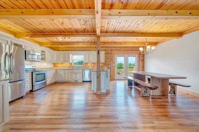 kitchen with appliances with stainless steel finishes, light wood-style flooring, wooden ceiling, plenty of natural light, and beamed ceiling