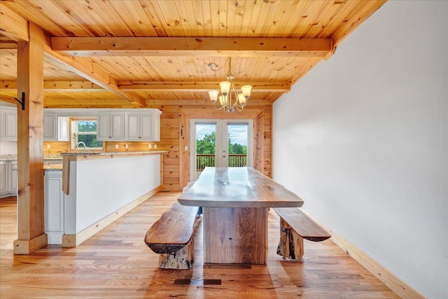 dining area featuring a chandelier, wood ceiling, light wood-type flooring, beam ceiling, and baseboards