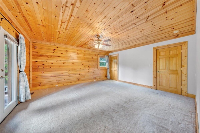 unfurnished room featuring wooden ceiling, carpet floors, wooden walls, and ceiling fan