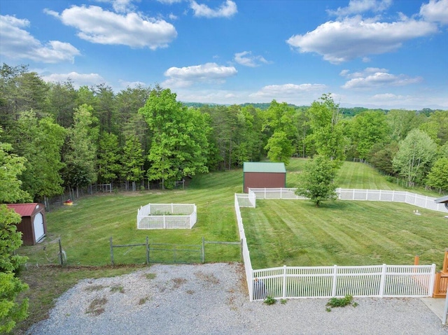 view of yard with an outdoor structure and a forest view