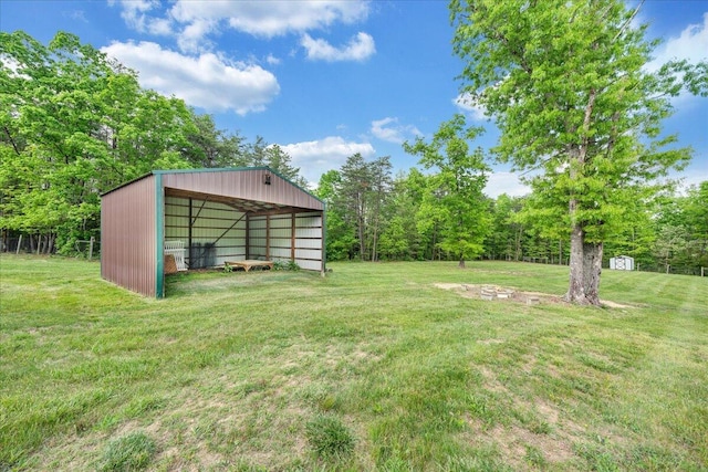 view of green lawn featuring a pole building, a carport, and an outdoor structure