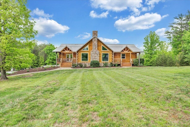view of front of home featuring a porch, a chimney, a front lawn, metal roof, and stone siding