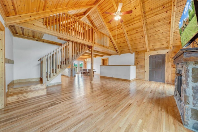 unfurnished living room featuring stairway, wooden ceiling, wood finished floors, high vaulted ceiling, and a fireplace