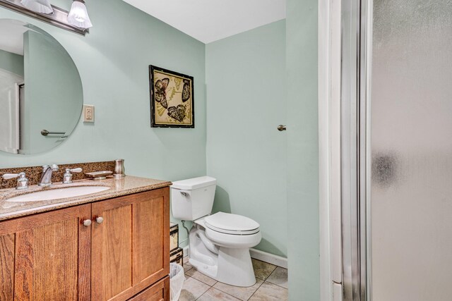 bathroom featuring tile patterned flooring, toilet, and vanity