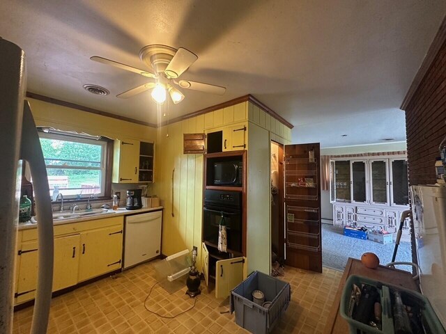 kitchen with black appliances, a sink, ceiling fan, light countertops, and crown molding