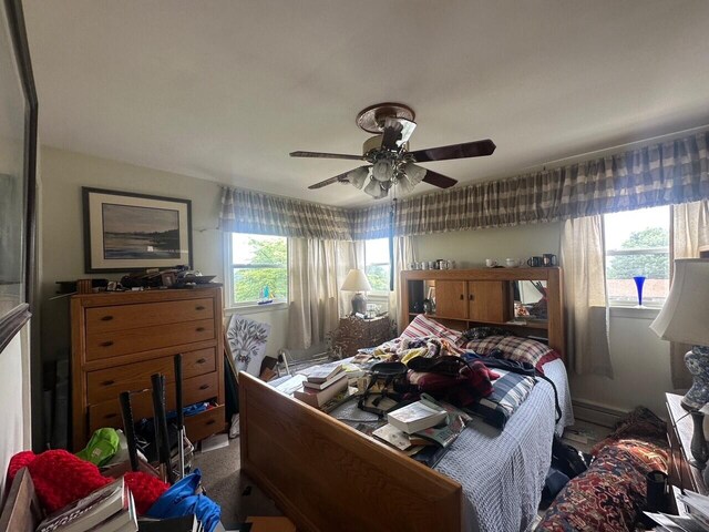 bedroom with a ceiling fan and an office area