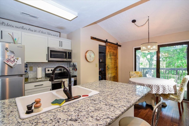 3279 Forest Ridge Rd, Roanoke, VA 24018 - kitchen featuring stainless steel appliances, a barn door, a sink, vaulted ceiling, and white cabinets