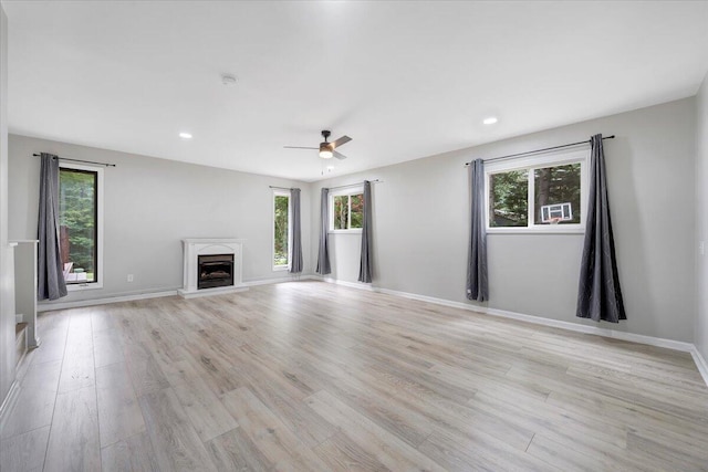 unfurnished living room featuring healthy amount of natural light, ceiling fan, light wood-style floors, and recessed lighting