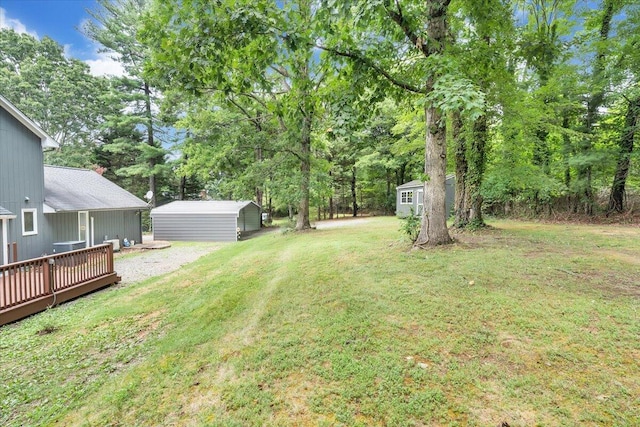 view of green lawn featuring a shed, an outbuilding, and a deck