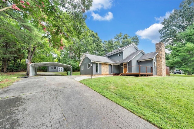 view of front facade with asphalt driveway, a chimney, a front yard, and a detached carport