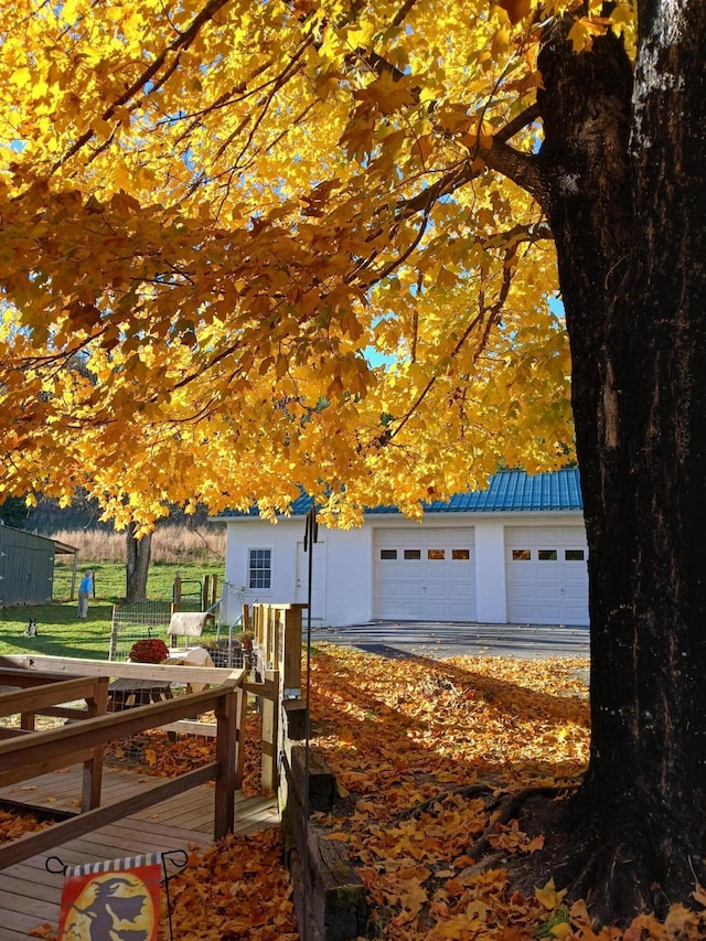 view of home's exterior featuring fence, a detached garage, and an outbuilding