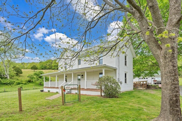 view of side of home with a porch and a yard
