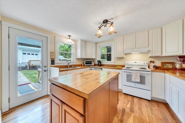 kitchen with electric range, under cabinet range hood, light wood finished floors, and a sink