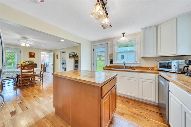 kitchen with a sink, wooden counters, dishwasher, light wood-type flooring, and white cabinetry