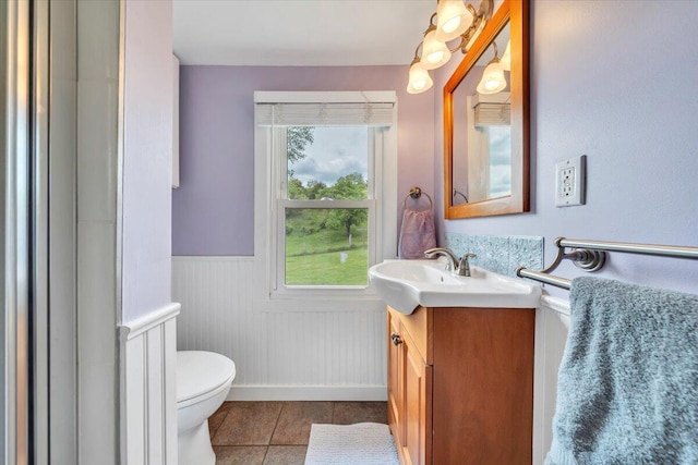 bathroom with wainscoting, tile patterned floors, vanity, and toilet