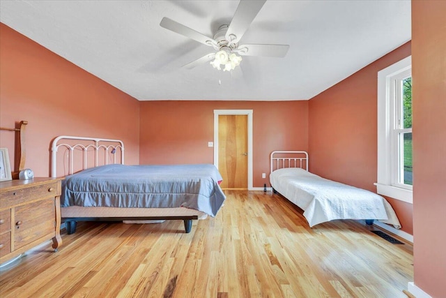 bedroom with wood finished floors, baseboards, and a ceiling fan