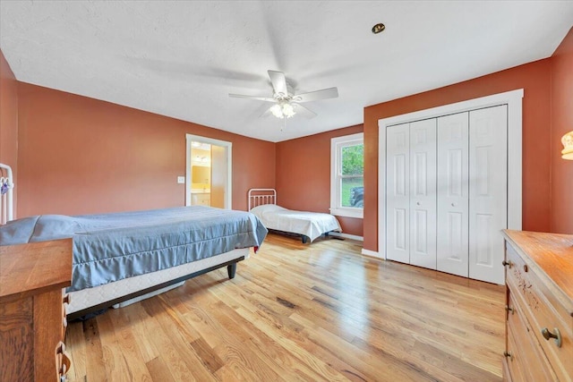 bedroom with light wood-style flooring, a closet, and ceiling fan