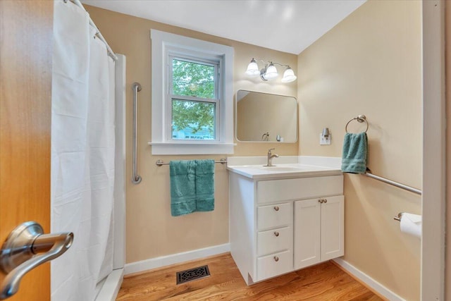 full bathroom with wood finished floors, vanity, baseboards, and a shower with curtain