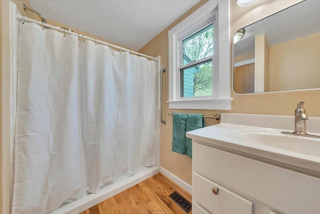 bathroom featuring wood finished floors, vanity, baseboards, and a shower with shower curtain