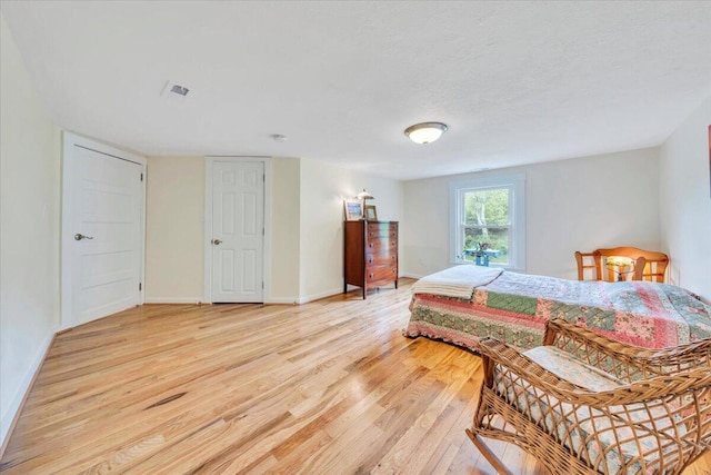 bedroom with light wood finished floors and baseboards