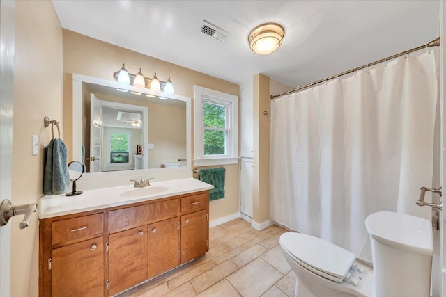 bathroom featuring toilet, vanity, and a shower with curtain