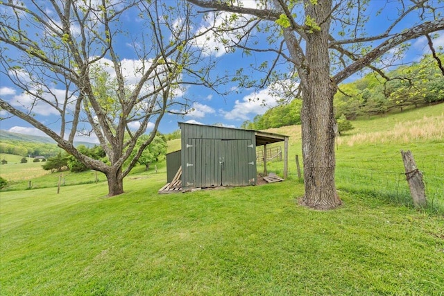 view of green lawn with an outdoor structure