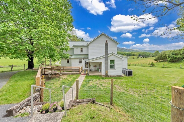 rear view of property with central AC unit and a wooden deck