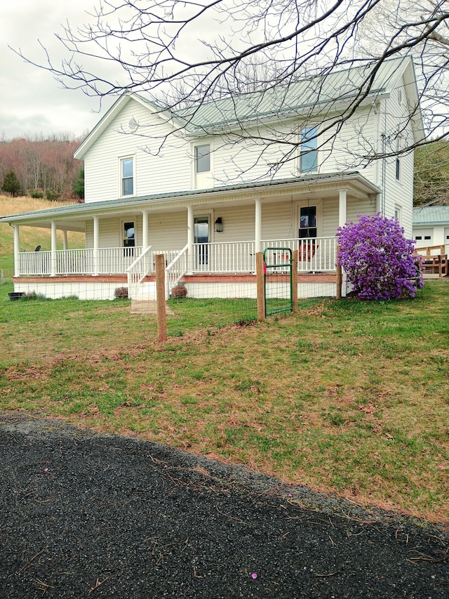 farmhouse featuring a porch and a front yard
