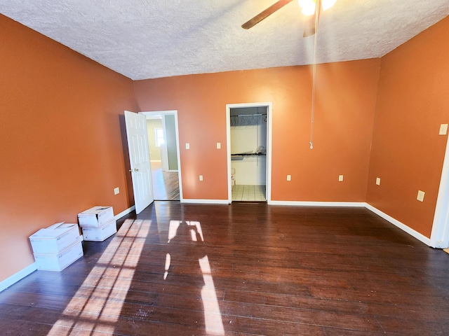 empty room featuring a textured ceiling, wood finished floors, ceiling fan, and baseboards