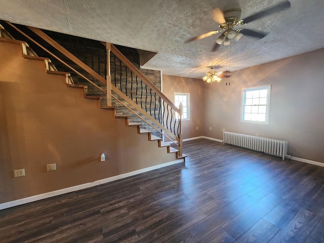 interior space featuring radiator heating unit, a ceiling fan, baseboards, stairway, and wood finished floors